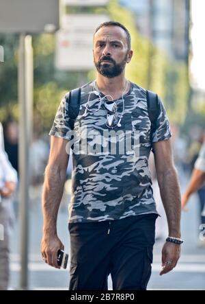 Uomo italiano con una maglietta camouflage a piedi in Piazza Umberto i, Via Sparano da Bari. Bari, Italia Foto Stock