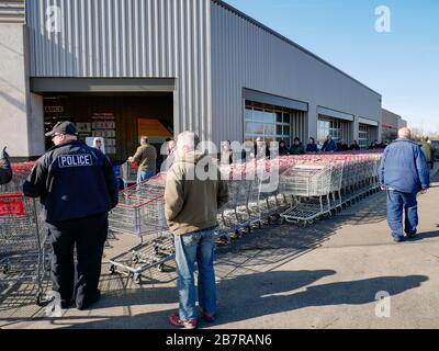 Melrose Park, Illinois, Stati Uniti. 17 marzo 2020. Gli acquirenti si allineano all'esterno di un magazzino Costco poco dopo l'apertura per le attività durante la pandemia COVID-19. Il negozio aveva già esaurito la carta igienica, il sapone liquido e l'igienizzante per le mani. Foto Stock