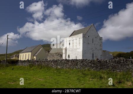 Clare Island Abbey circondata dal verde sotto un cielo blu E luce solare in Irlanda Foto Stock