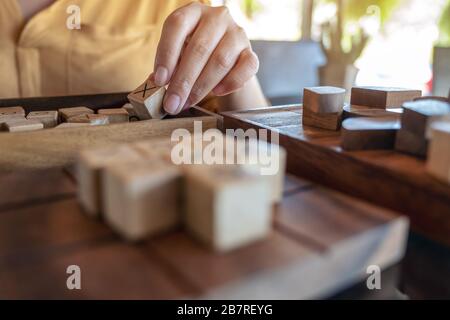 Immagine closeup di persone che giocano a Tic TAC Toe gioco di legno o OX gioco Foto Stock