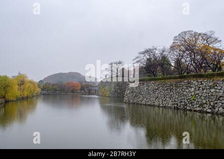 Il fiume intorno alle mura del castello di Himeji in autunno Foto Stock