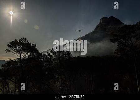 Gli elicotteri combattono un fuoco selvaggio sulle pendici del Lion's Head di Città del Capo e un iconico monumento sudafricano Foto Stock