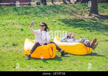 Giovane posa in city park su giallo materasso gonfiabile Foto Stock