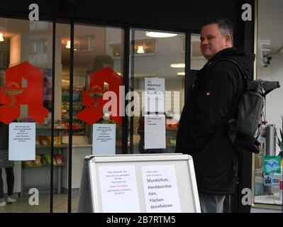 Francoforte, Germania. 17 Marzo 2020. Un uomo attende al di fuori di una farmacia che limita il numero di clienti tra le preoccupazioni di coronavirus a Francoforte, Germania, 17 marzo 2020. Il rischio generale per la salute della popolazione in Germania è stato aumentato da "moderate" a "high", l'agenzia federale tedesca per il controllo delle malattie Robert Koch Institute (RKI) ha annunciato martedì. Il numero di casi confermati di coronavirus in Germania è salito a oltre 6,000 lunedì. Il governo tedesco ha introdotto un pacchetto di misure rigorose per ridurre i contatti sociali. Credit: LU Yang/Xinhua/Alamy Live News Foto Stock