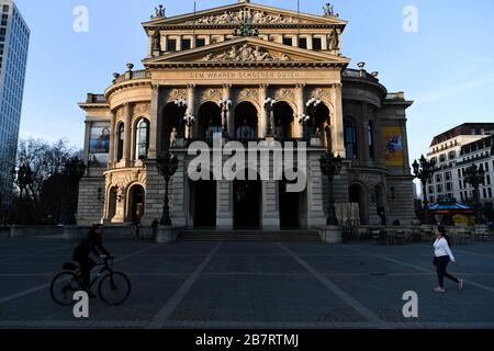 Francoforte, Germania. 17 Marzo 2020. La gente passa accanto alla Alte Oper temporaneamente chiusa a Francoforte, Germania, 17 marzo 2020. Il rischio generale per la salute della popolazione in Germania è stato aumentato da "moderate" a "high", l'agenzia federale tedesca per il controllo delle malattie Robert Koch Institute (RKI) ha annunciato martedì. Il numero di casi confermati di coronavirus in Germania è salito a oltre 6,000 lunedì. Il governo tedesco ha introdotto un pacchetto di misure rigorose per ridurre i contatti sociali. Credit: LU Yang/Xinhua/Alamy Live News Foto Stock