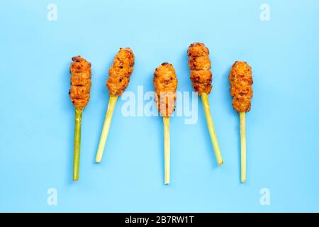 Pollo tritato alla griglia con pasta di curry e crema di cocco su spiedini di limongrass. Vista dall'alto Foto Stock