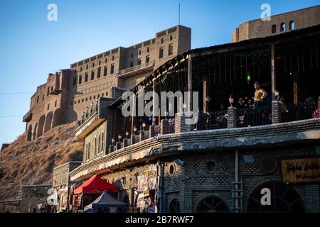 Iraq, Kurdistan iracheno, Arbil, Erbil. Vista da una caffetteria che si affaccia sulla strada al primo piano. Sullo sfondo è Erbil Qalat cittadella al tramonto. Foto Stock