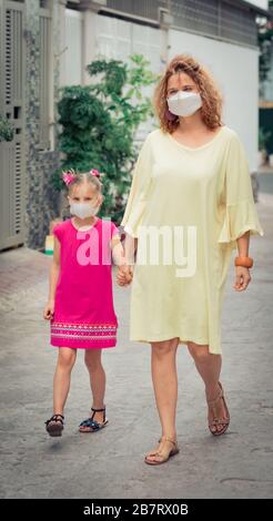 Donna e figlia che indossano maschera facciale monouso per evitare infezioni virali. Protezione da coronavirus Foto Stock