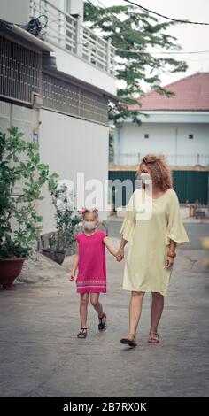 Donna e figlia che indossano maschera facciale monouso per evitare infezioni virali. Protezione da coronavirus Foto Stock