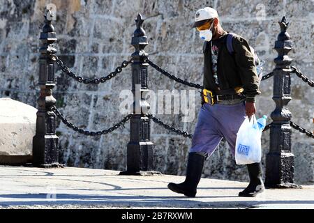 (200318) -- L'AVANA, 18 marzo 2020 (Xinhua) -- un pedone che indossa una maschera facciale cammina lungo una strada a l'Avana, Cuba, 17 marzo 2020. Una nave da crociera che trasporta cinque passeggeri britannici che hanno provato positivo per il COVID-19 ha raggiunto le acque territoriali cubane, Jose Antonio Fernandez, vice capo delle comunicazioni al Ministero degli Affari Esteri, ha detto martedì. I passeggeri interessati devono essere ritrasportati nel loro paese su quattro voli charter operati da British Airlines. Cuba ha accettato una richiesta del governo britannico di consentire alla nave da crociera MS Braemar di imbarcarsi sull'isola dopo di essa Foto Stock