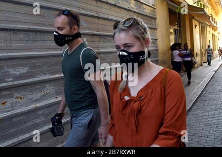 (200318) -- L'AVANA, 18 marzo 2020 (Xinhua) -- persone che indossano maschere facciali camminano lungo una strada a l'Avana, Cuba, 17 marzo 2020. Una nave da crociera che trasporta cinque passeggeri britannici che hanno provato positivo per il COVID-19 ha raggiunto le acque territoriali cubane, Jose Antonio Fernandez, vice capo delle comunicazioni al Ministero degli Affari Esteri, ha detto martedì. I passeggeri interessati devono essere ritrasportati nel loro paese su quattro voli charter operati da British Airlines. Cuba ha accettato una richiesta del governo britannico di consentire alla nave da crociera MS Braemar di attraccare sull'isola dopo che è stata girata Foto Stock