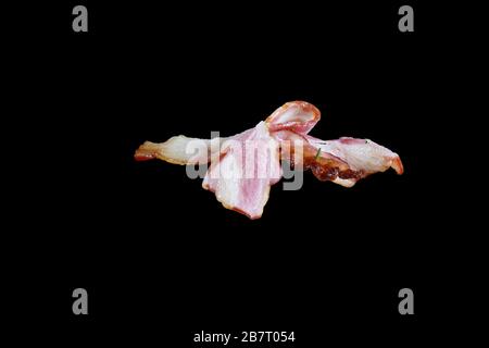 Pancetta su uno spiedino su uno sfondo nero Foto Stock