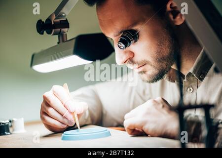 Vista laterale del matchmaker con pinzette per vassoio portautensili e lampada sul tavolo Foto Stock