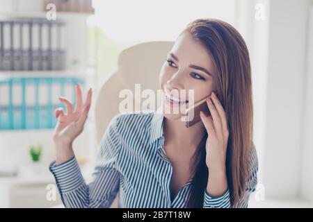 Primo piano ritratto di allegra donna d'affari, che sta parlando al telefono in ufficio. È sognante e sorridente Foto Stock