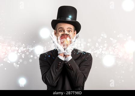 mago professionista con sfera magica isolata in grigio con una brillante illustrazione Foto Stock