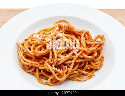 Spaghetti con salsa bolognese e parmigiano. Pasta fresca italiana su un piatto bianco. Primo piano Foto Stock