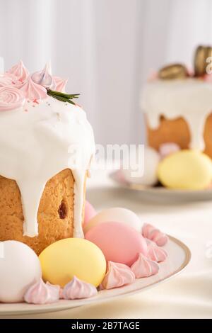 Selezione di deliziosi dolci pasquali con meringa e uova colorate sui piatti Foto Stock