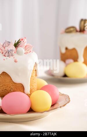 Selezione di deliziosi dolci pasquali con meringa e uova colorate sui piatti Foto Stock