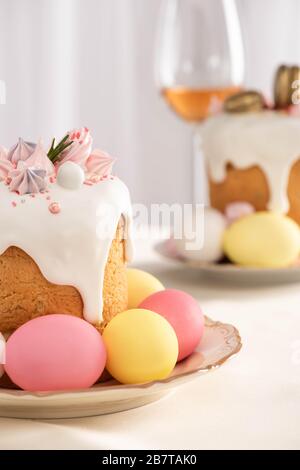 Selezione di deliziosi dolci pasquali con meringa e uova colorate sui piatti Foto Stock