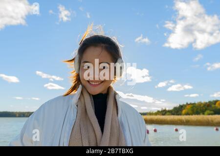Felice giovane bella donna asiatica contro la vista del mare e del cielo Foto Stock