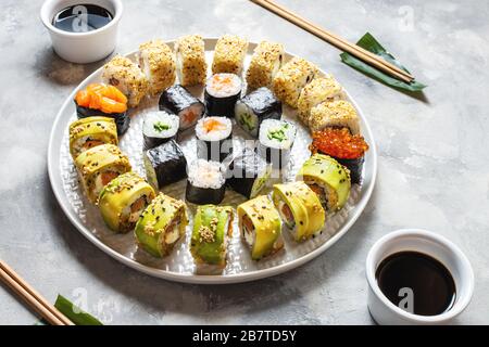 Vari tipi di sushi serviti su sfondo concreto. Foto Stock