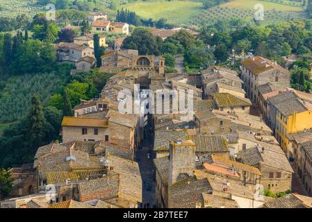 I tetti del centro storico di San Gimignano e di Via S. Giovanni terminano con porta San Giovanni vista dalla Grande Torre grossa, San Gimignano Italia Foto Stock