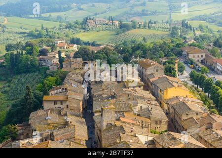 I tetti del centro storico di San Gimignano e di Via S. Giovanni terminano con porta San Giovanni vista dalla Grande Torre grossa, San Gimignano Italia Foto Stock