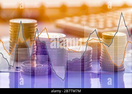 Monete in euro in pila su banconote in euro con calcolatrice e grafici, per sfondo. Germania Foto Stock