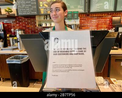 17 marzo 2020, Montecito, California, U.S: Starbucks ha smesso di servire le bevande in tazze riutilizzabili per aiutare a fermare la diffusione di Covid-19, l'infezione batterica derivante da un virus Corona. Un dipendente consegna il cambiamento in un negozio quasi vuoto. (Credit Image: © Amy Katz/ZUMA Wire) Foto Stock