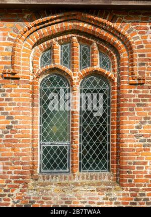 Storica chiesa parrocchiale villaggio a Kenton, Suffolk, Inghilterra, UK mattoni rossi Tudor finestra dettagli architettonici Foto Stock