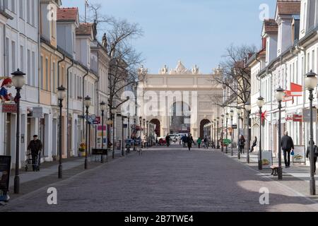 18 marzo 2020, Brandeburgo, Potsdam: Solo pochi passanti attraversano il Brandenburger Straße, che corre in direzione della porta di Brandeburgo, alle 11:19. Numerosi negozi nel viale dello shopping, che è altrimenti occupato nei giorni feriali, hanno dovuto rimanere chiusi a causa delle precauzioni corona. Foto: Soeren Stache/dpa-Zentralbild/ZB Foto Stock