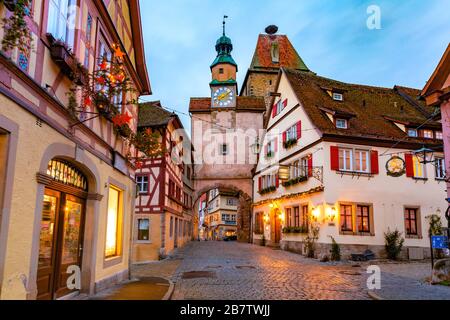 Arredato ed illuminato il Natale street con porta e torre Markusturm nella vecchia città medievale di Rothenburg ob der Tauber, Baviera, Germania meridionale Foto Stock