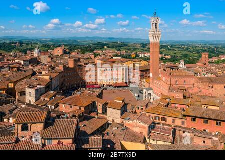 Piazza del campo con il Palazzo pubblico e l'adiacente Torre del Mangia vista dal Facciatone, una terrazza panoramica, a Siena, Toscana, Italia. Foto Stock