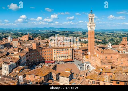 Piazza del campo con il Palazzo pubblico e l'adiacente Torre del Mangia vista dal Facciatone, una terrazza panoramica, a Siena, Toscana, Italia. Foto Stock