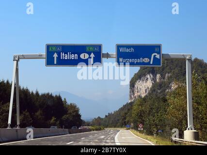 Cartello autostradale vicino al confine tra Italia e Austria e Slovenia il villaggio di Villach Foto Stock
