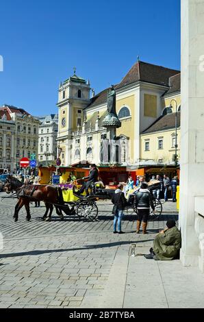 Vienna, Austria - 27th marzo 2016: Persone non identificate, pullman trainato da cavalli chiamato Fiaker, fontana austriaca e monastero scozzese in piazza Freyung Foto Stock