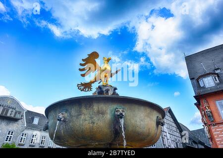 Goslar Germania vecchio mercato storico con bene e aquila d'oro in cima Foto Stock