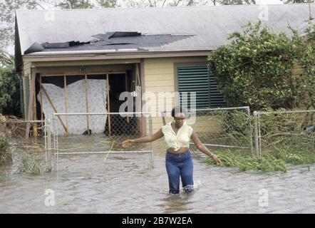 Galveston, Texas USA, 1983: Residente svanisce attraverso le acque alluvionali profonde di fronte a casa danneggiato da forti venti e tempesta di impennata dall'uragano Alicia. ©Bob Daemmrich Foto Stock