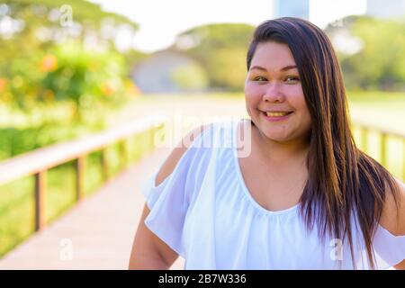 Bellissimo il sovrappeso donna asiatica di relax presso il parco Foto Stock