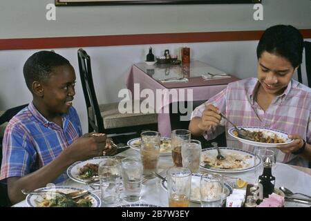 Austin Texas USA: Ragazzi di 13 anni che condividono un pasto in un ristorante cinese. ©Bob Daemmrich Foto Stock