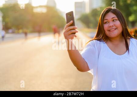 Bellissimo il sovrappeso donna asiatica di relax presso il parco Foto Stock