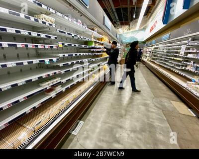 Montecito, Stati Uniti. 17 Marzo 2020. 17 marzo 2020, Santa Barbara, California, U.S: Gli addetti alle scorte riimmagazzinano gli scaffali vuoti a Whole Foods. Gli scaffali vuoti sono una vista inusuale in Santa Barbara, ma stanno diventando la norma durante la pandemia Corona Virus/Covid-19. In questo negozio attento alla salute, Kambucha e yogart vanno così rapidamente come acqua, pane, latte, patate, carne, banane, zuppe e altri prodotti in scatola che scompaiono dagli scaffali qui e in tutti gli altri negozi di alimentari in città. La maggior parte degli altri ripiani sono ancora pieni. La scarsità è già fastidioso acquirenti, alcuni che indossano maschere e. Foto Stock