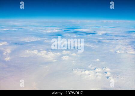 Un paesaggio nuvolato da una finestra di un aereo da qualche parte al largo della costa del Portogallo Foto Stock