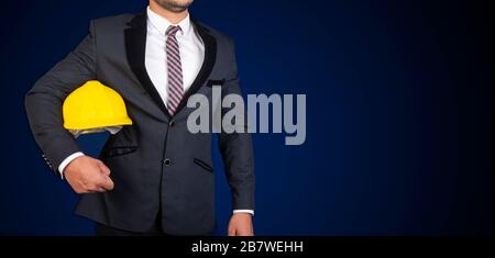 Ingegnere civile in tuta con cappuccio di sicurezza giallo in braccio con spazio copia banner Foto Stock