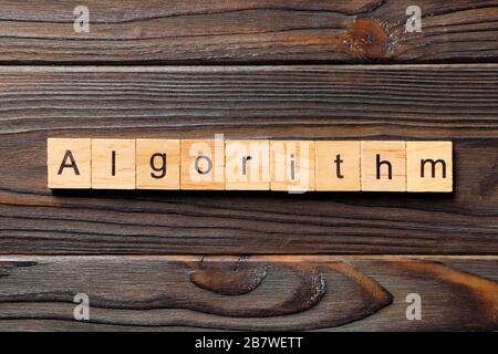Parola di algoritmo scritta su blocco di legno. Testo algoritmo su tavola in legno per il concetto di desing, vista dall'alto. Foto Stock
