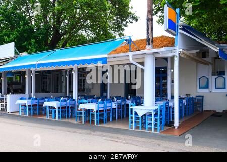 THASSOS, Grecia - 5 maggio 2018: Taverna greca tradizionale all'aperto, bar e ristorante con sedie e tavoli blu e bianchi, Grecia Foto Stock