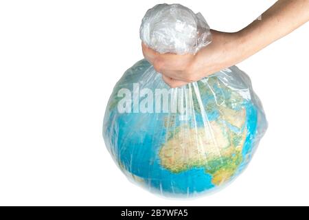 La mano umana tiene la terra in cattività. Globo in un sacchetto di plastica bianco. Il concetto di disastro ambientale su un fondo bianco isolato Foto Stock