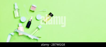 Un gruppo di piccoli flaconi per viaggiare su sfondo verde. Copia dello spazio per le vostre idee. Appartamento stabilire la composizione dei prodotti cosmetici. Vista superiore della crema con Foto Stock