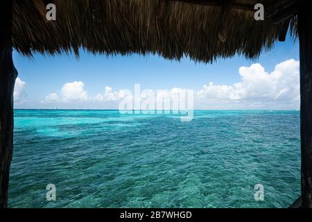 Tetto di paglia di una capanna d'acqua che si affaccia sul mare dei Caraibi a Isla Mujeres Messico, viaggio e natura concetto Foto Stock