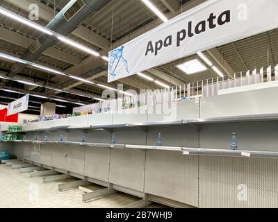 BUCAREST, ROMANIA - 18 MARZO 2020: Panico acquirenti e bottiglie d'acqua carenza nel supermercato Store a causa di Pandemic Coronavirus Foto Stock